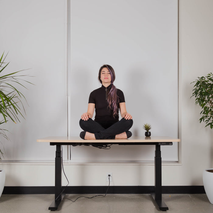 Woman sitting on electric standing desk from EFFYDESK