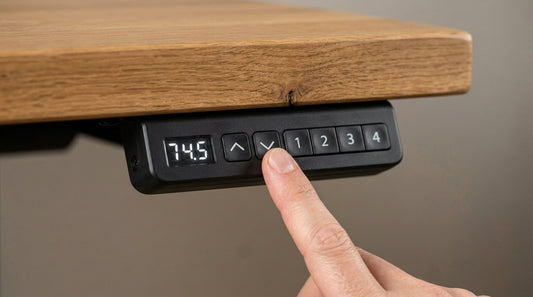 A fingertip pressing the down button on an effydesk standing desk memory keypad mounted under the desktop